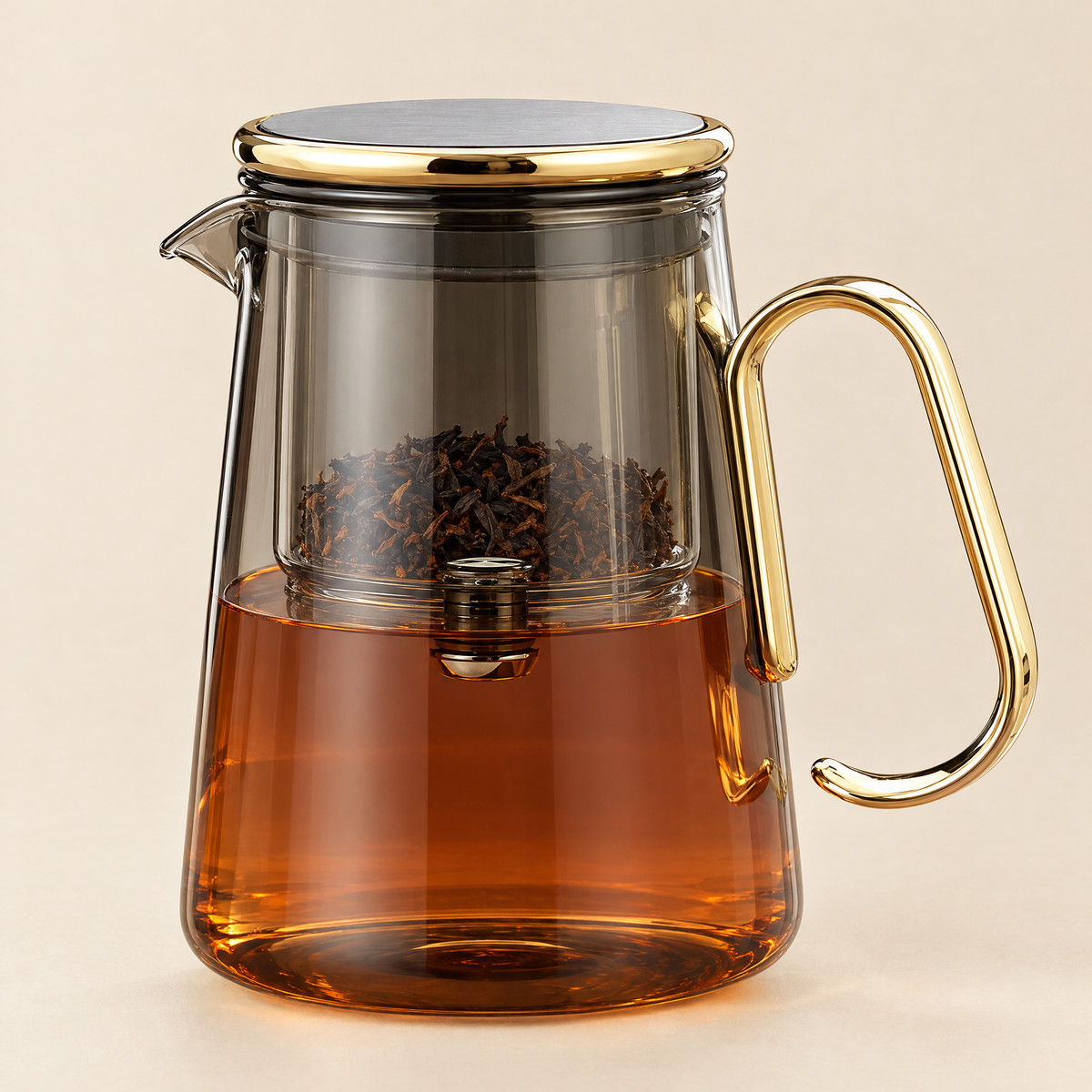 The Lumen Teapot in smoke glass with gold trim, filled with amber tea, on a cream background